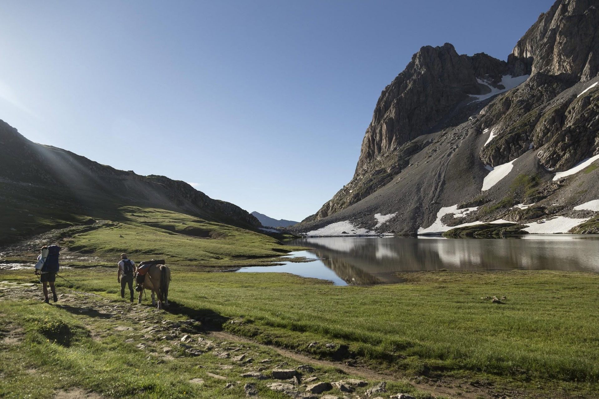 Marche vers un lac d'altitude au pied des falaises